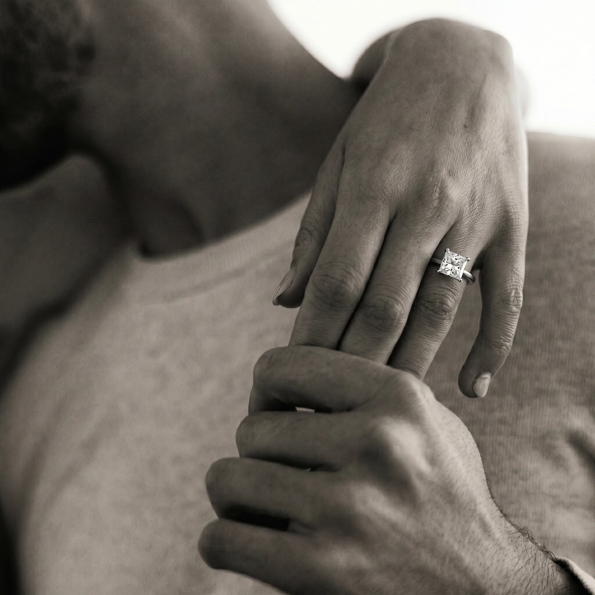 Anillo de compromiso corte princesa sobre mano en fotografía lifestyle en blanco y negro