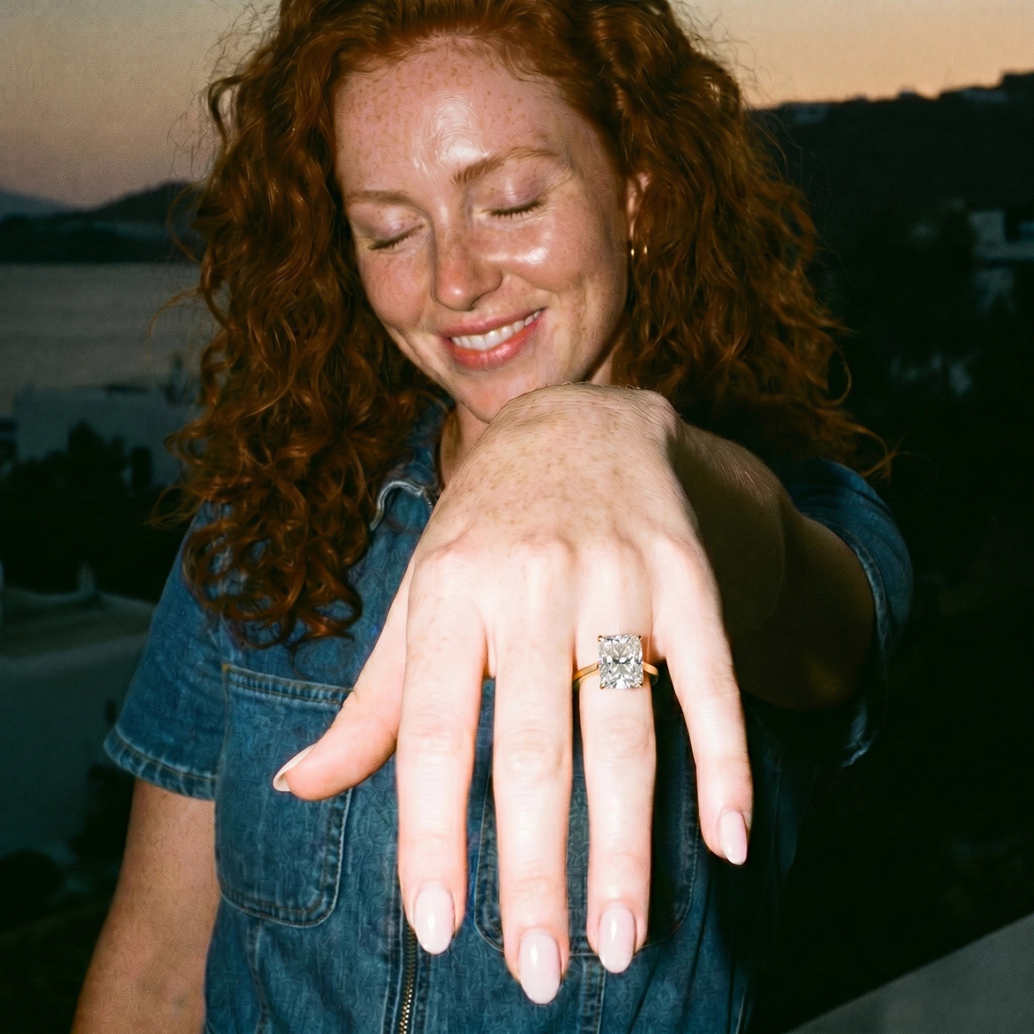 Anillo de compromiso corte radiante sobre mano en retrato lifestyle con flash