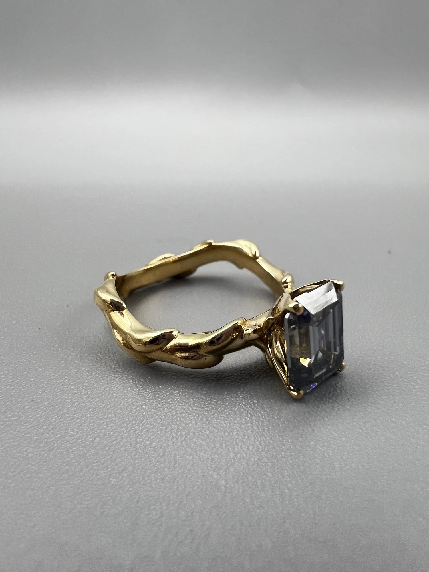 Anillo solitario de moissanita gris talla esmeralda en oro amarillo 14k con espinas, hecho a medida por BRAVORA