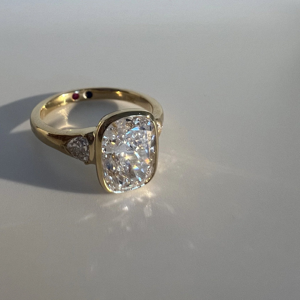 Anillo trilogía con diamante lab-grown de corte cojín elongado en oro amarillo 18k hecho a medida por BRAVORA