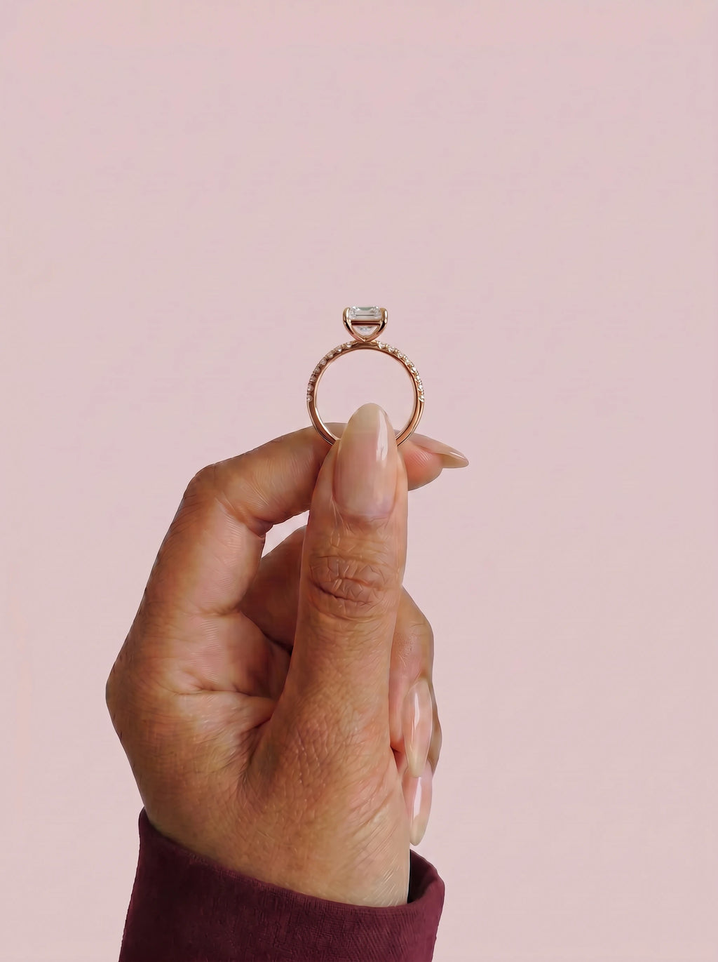 Anillo de compromiso AURORA esmeralda en oro rosa, detalle sujeto con pinza