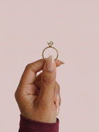 Anillo de compromiso AURORA oval en oro amarillo, detalle sujeto con pinza