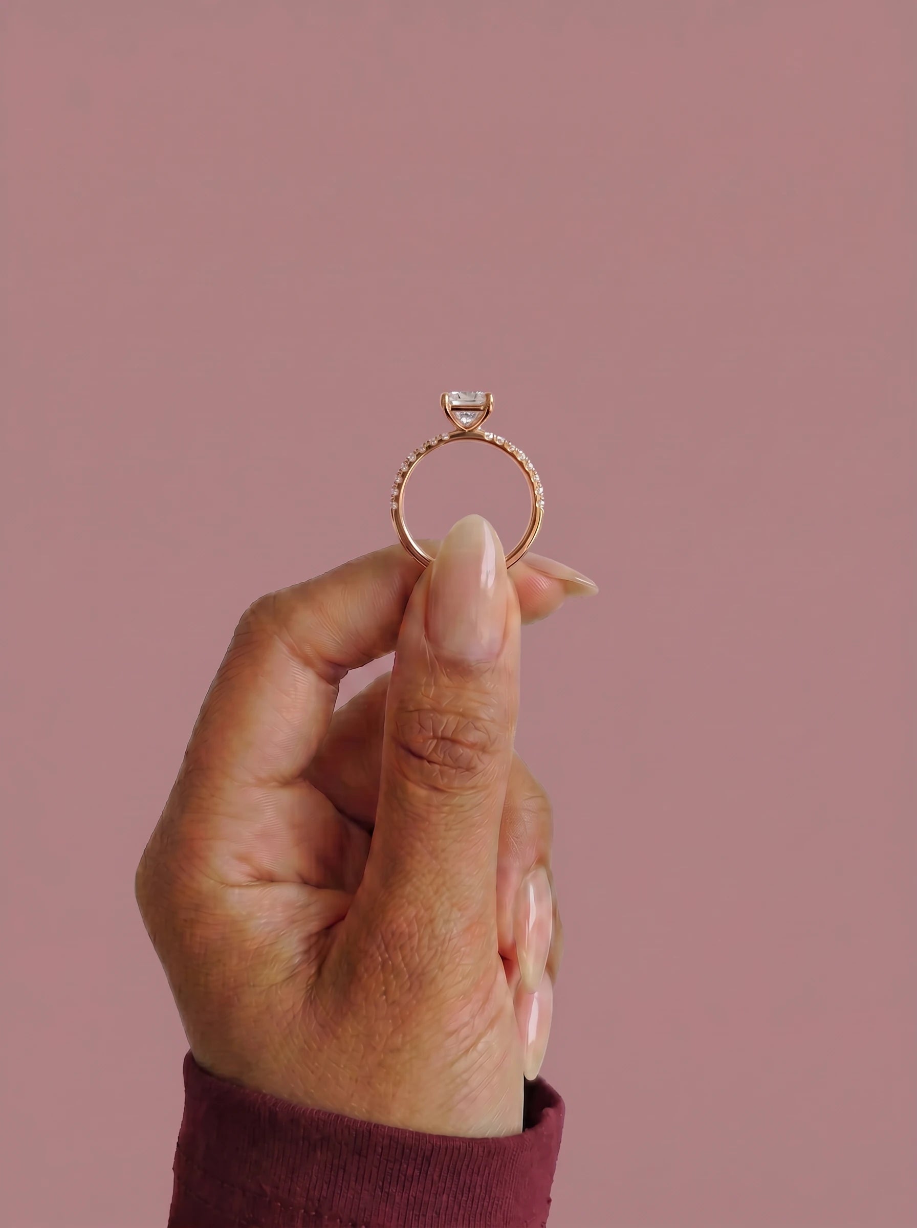 Anillo de compromiso AURORA radiante en oro rosa, detalle sujeto con pinza