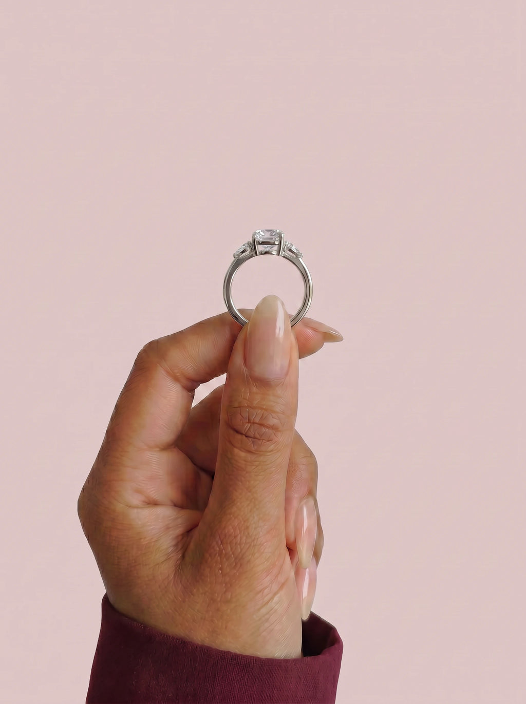 Anillo de compromiso ELARA Cojín trilogía sujeto con los dedos - vista frontal