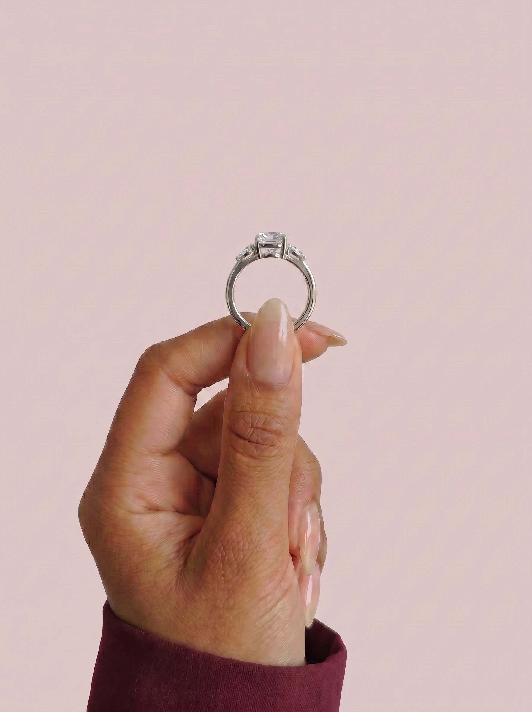 Anillo de compromiso ELARA Cojín trilogía sujeto con los dedos - vista frontal