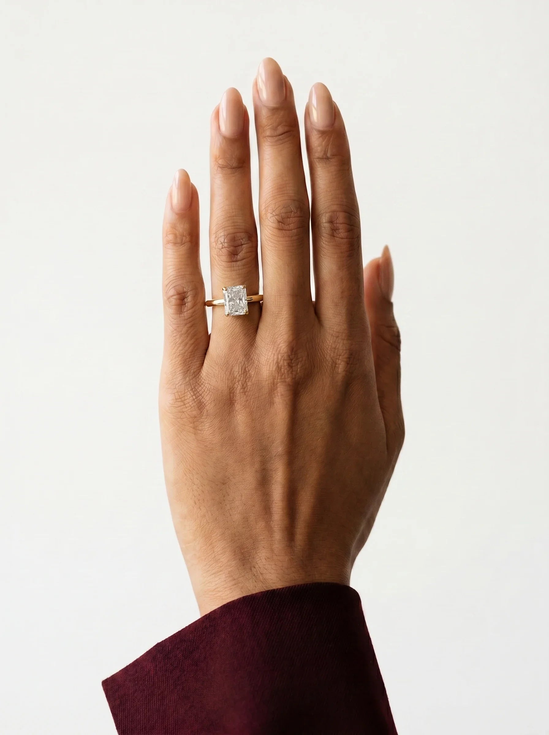 Anillo de compromiso GAIA radiante solitario en oro amarillo 18k en la mano