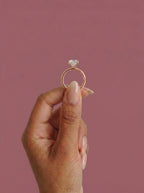 Anillo de compromiso solitario halo escondido THEIA cojin en oro rosa, detalle sujeto con pinza