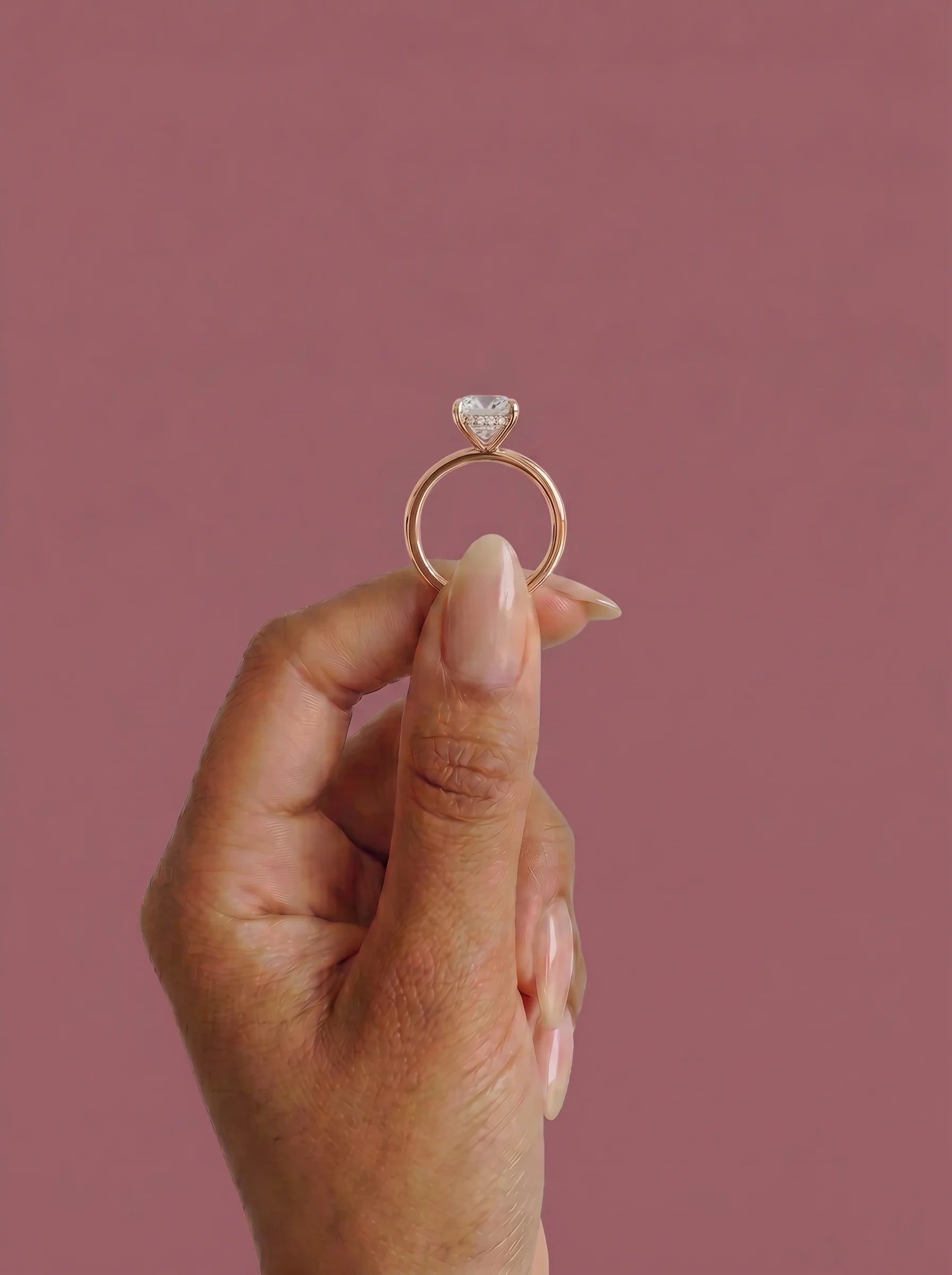 Anillo de compromiso solitario halo escondido THEIA cojin en oro rosa, detalle sujeto con pinza