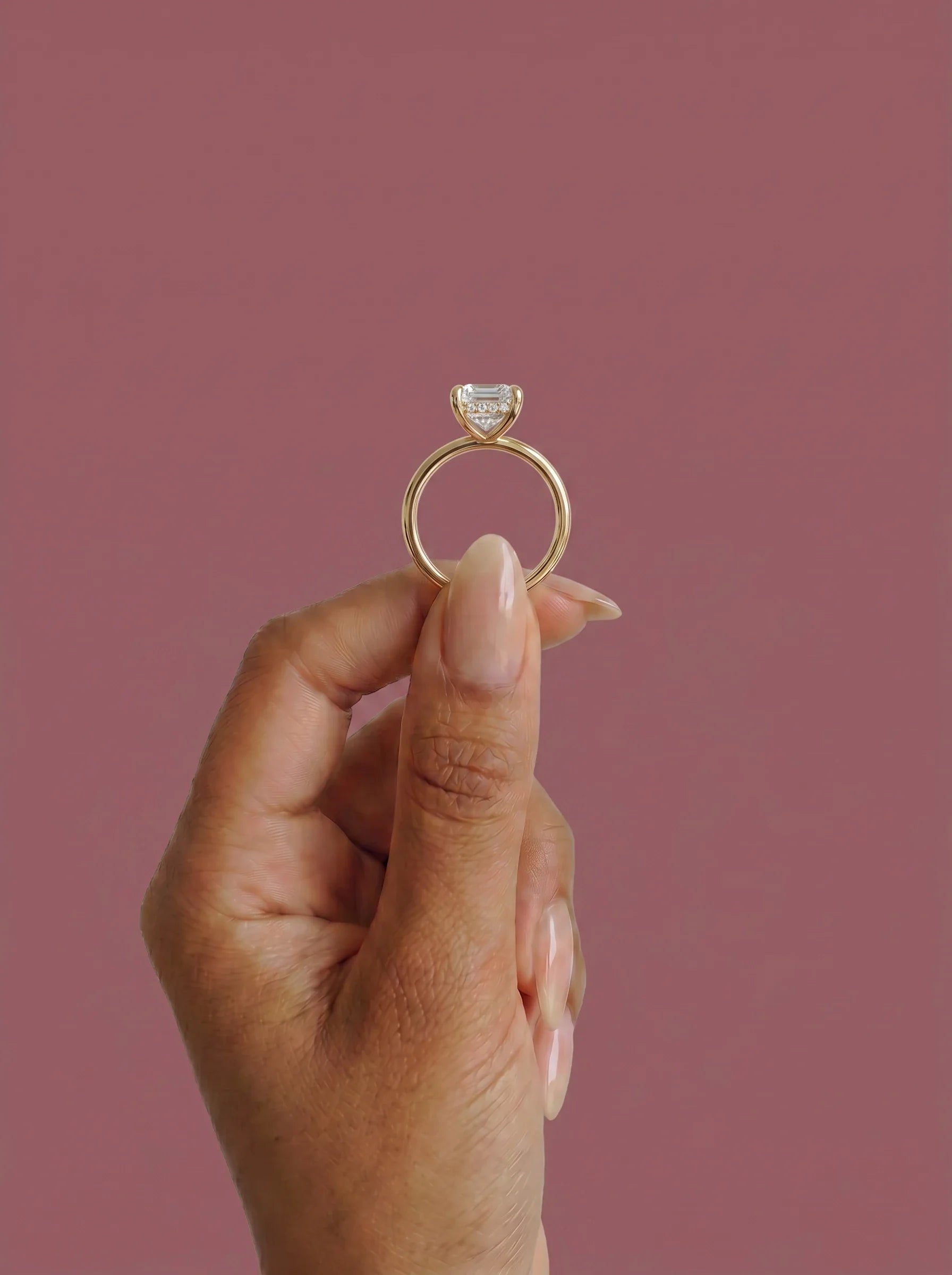 Anillo de compromiso solitario halo escondido THEIA esmeralda en oro amarillo, detalle sujeto con pinza