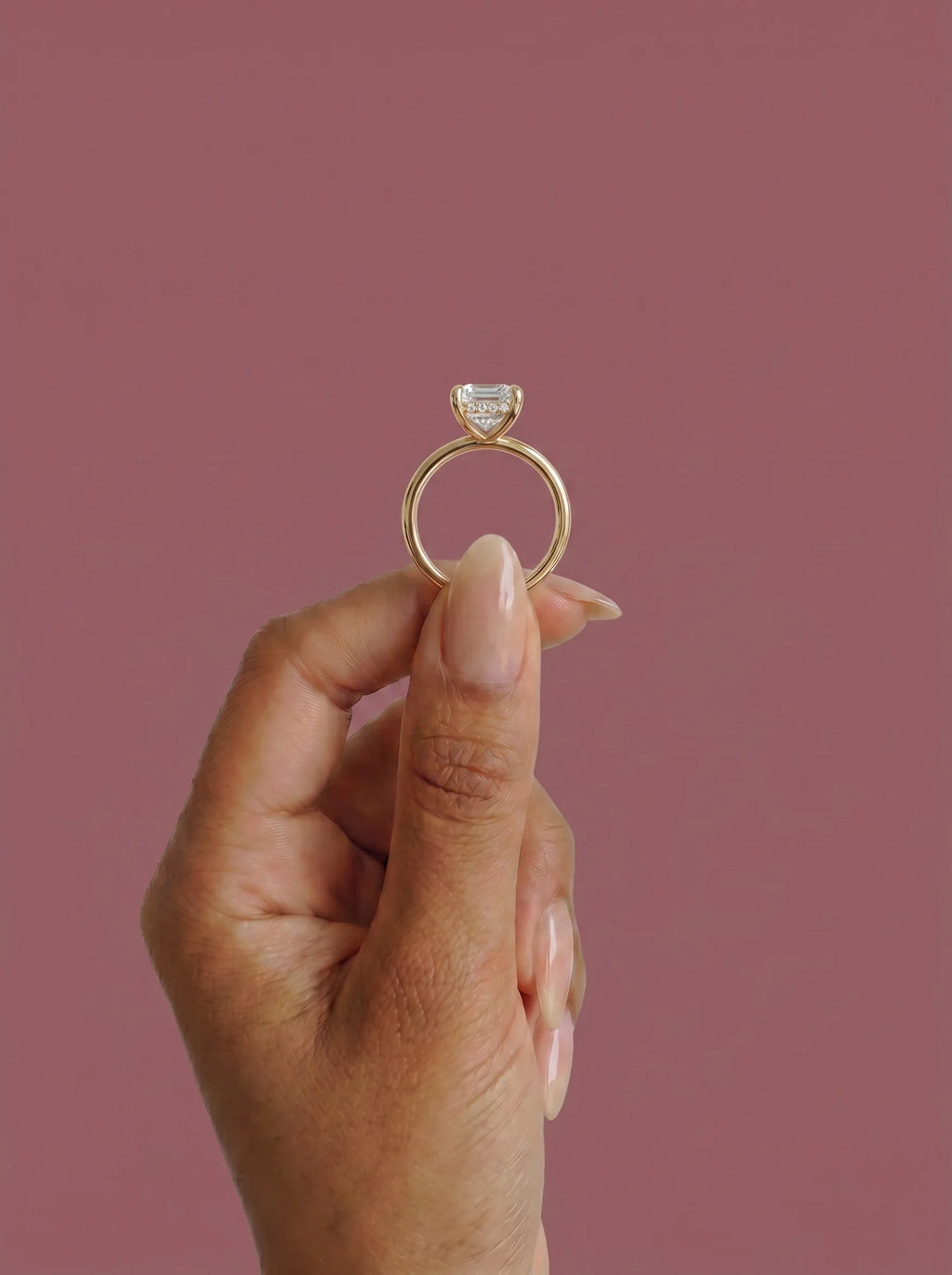 Anillo de compromiso solitario halo escondido THEIA esmeralda en oro amarillo, detalle sujeto con pinza