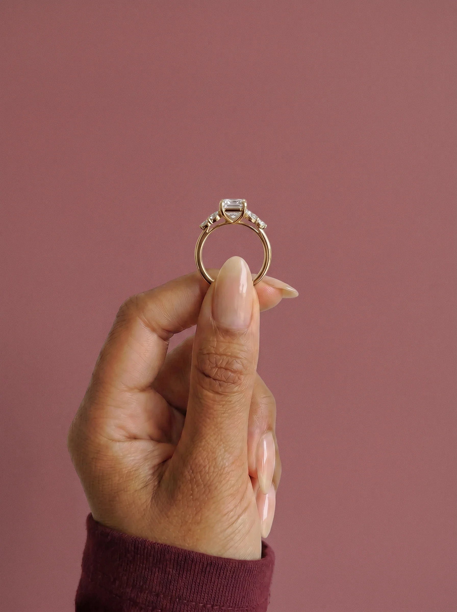 Anillo de compromiso clúster VESTA esmeralda en oro amarillo, detalle sujeto con pinza