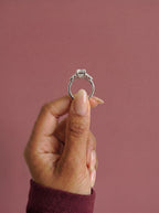 Anillo de compromiso clúster VESTA esmeralda en oro blanco, detalle sujeto con pinza