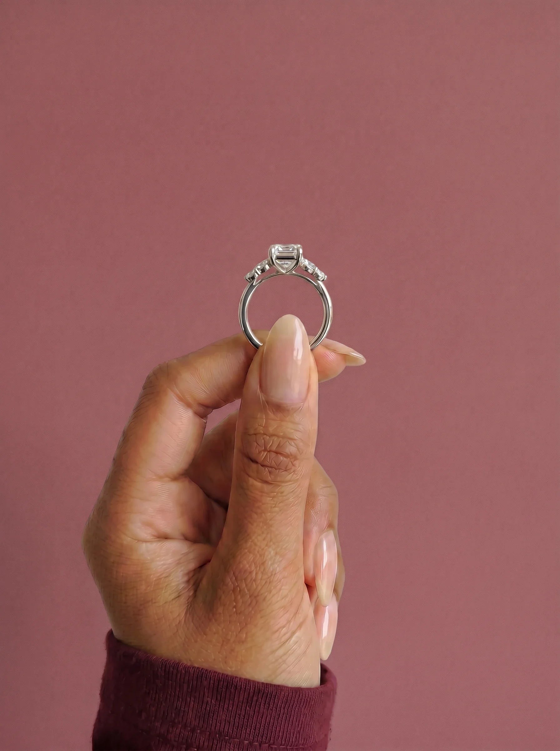 Anillo de compromiso clúster VESTA esmeralda en oro blanco, detalle sujeto con pinza