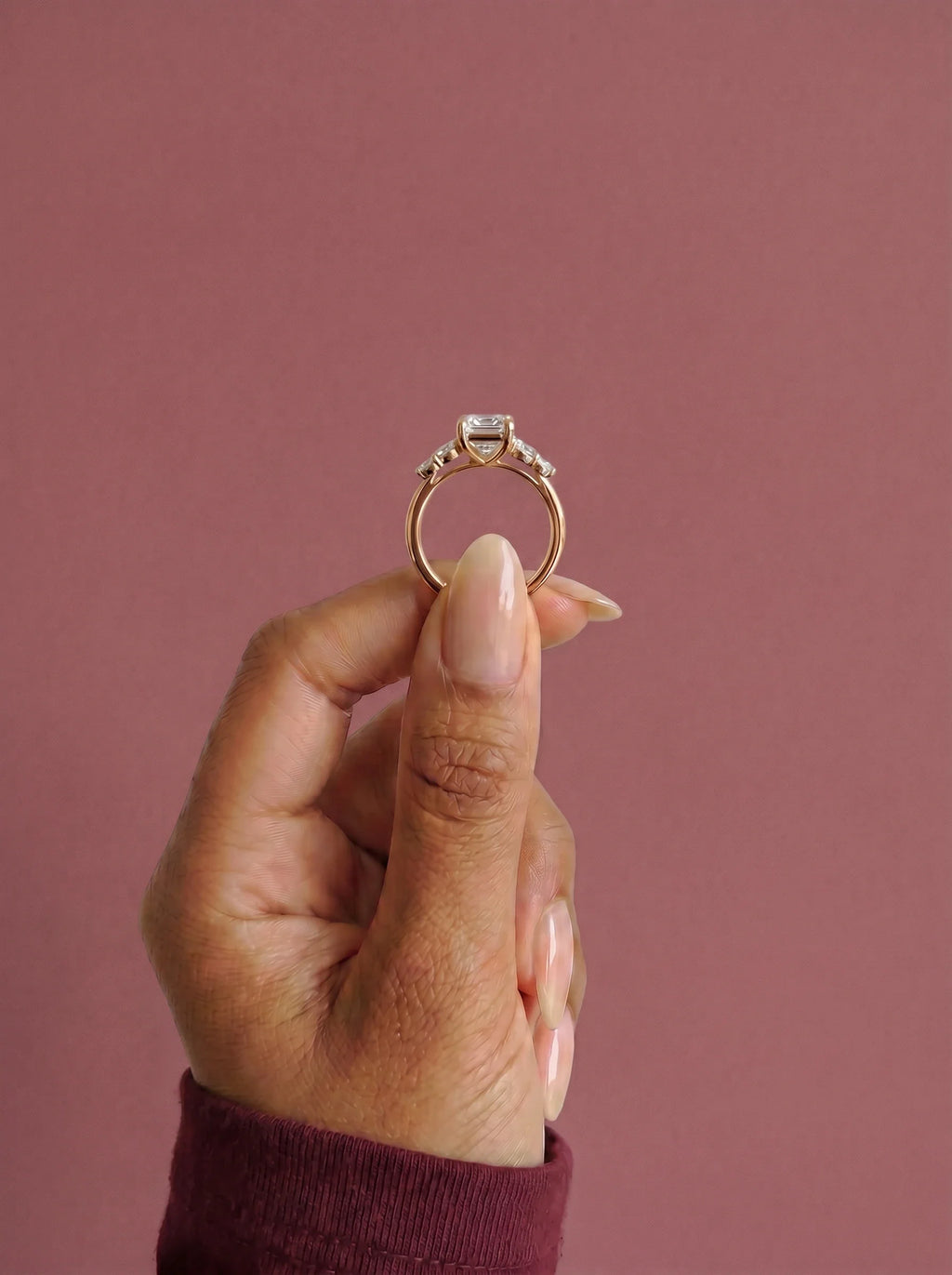 Anillo de compromiso clúster VESTA esmeralda en oro rosa, detalle sujeto con pinza