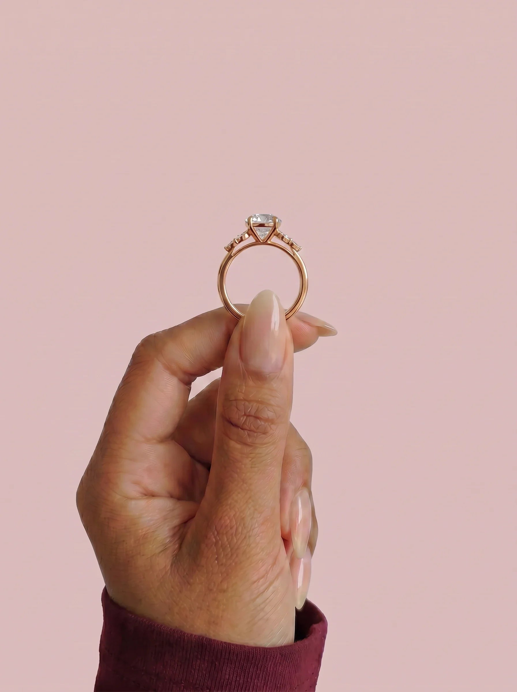 Anillo de compromiso clúster VESTA oval en oro rosa, detalle sujeto con pinza